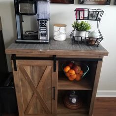 a small wooden cabinet with some fruit on it and a coffee maker in the background