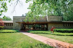 the house is surrounded by hedges and trees