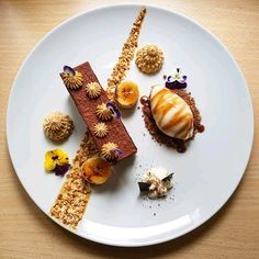 a white plate topped with desserts on top of a wooden table