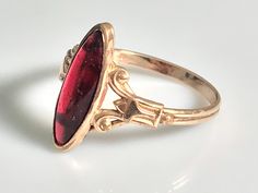 Very pretty antique ruby navette ring from the Victorian era in 10K yellow gold. This lovely ring features a marquise-cut cabochon ruby in a classic late Victorian oval bezel mount. The ruby is a simulated ruby, typical of the era, and measures 16.4x6mm and appears to be original to the ring with no chips or cracks and only very minimal age related wear. Beautiful. classic late Victorian-Art Nouveau detail to the sides. The shank is a beautiful handmade double shank and is solid all around. Ring Antique Marquise 14k Gold Rings, Antique 14k Gold Marquise Ring, Antique Marquise Rings For Formal Occasions, Antique Marquise Gold Ring, Antique Gold Marquise Ring, Antique 14k Gold Oval Ruby Ring, Antique Oval Ruby Ring In 14k Gold, Vintage Marquise Ruby Ring In Red, Art Deco Oval Ruby Ring In Gold