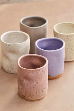 four different colored cups sitting on top of a table