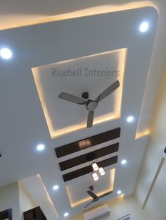 a ceiling fan mounted to the side of a wall in a room with white walls