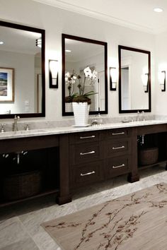 a large bathroom with double sinks and two mirrors on the wall, along with an area rug