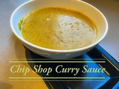 a white bowl filled with soup sitting on top of a black tray next to a cup