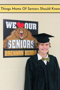 a young man wearing a cap and gown standing in front of a sign that says we our seniors