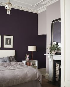 a bedroom with purple walls and white trim