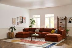 a living room filled with lots of furniture next to a large window on top of a hard wood floor