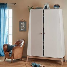 a living room with a chair and cabinet in it