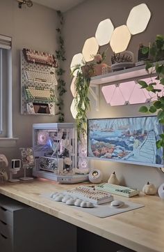 a desk with a computer, keyboard and plant on it in front of a window