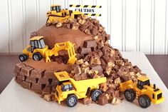 a cake made to look like a pile of dirt with construction vehicles on top and the words caution above it