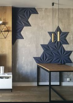 a living room filled with furniture next to a wall covered in geometric shapes and hanging lights