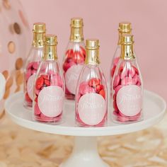 pink and gold confetti in glass bottles on a cake plate