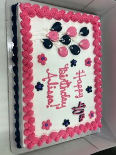 a pink and white birthday cake with minnie mouse decorations on it's icing