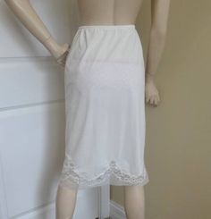 You are buying a vintage 1960s half slip in white with pretty lace and organza trim. Vintage lingerie. Vintage clothing. Mid century clothing. The slip has pretty scalloped lace at the bottom set onto nylon organza with straight edge. Size small. The elastic waist measures about 21 inches without stretching. It will stretch to about 27-28 inches. The slip is 27.5 inches long. Hips: about 39 inches. Nylon fabric. No tag inside. Very pretty and a fabulous slip in its day! Check out the rest of my White Stretch Hosiery With Lace Trim, White Stretch Lace Trim Hosiery, Fitted White Hosiery With Lace Trim, Stretch Lace Trim Slip For Daywear, Fitted Slip For Daywear, Stretch Slip For Summer Daywear, Stretch Slip For Daywear In Summer, Mid Century Clothing, Lingerie Vintage