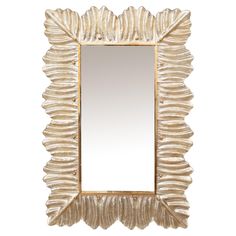 a mirror that is sitting on top of a white surface with gold trimmings