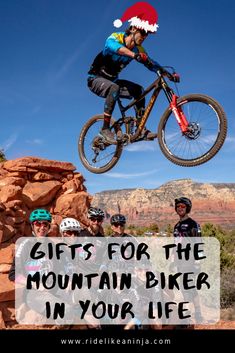 a man on a mountain bike jumping over rocks with the words gifts for the mountain biker in your life