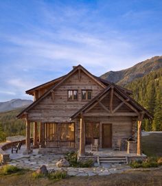 an old log cabin sits in the mountains