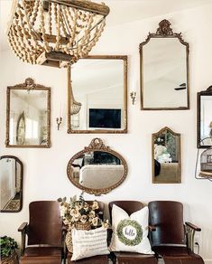 a living room filled with furniture and lots of mirrors on the wall next to a chandelier