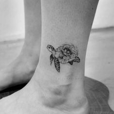 a small turtle and flower tattoo on the ankle