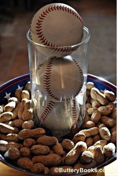 two baseballs and nuts in a glass on a plate