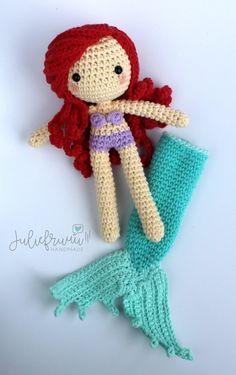 a crocheted mermaid doll laying on top of a blanket