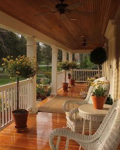 a porch with wicker chairs and potted plants