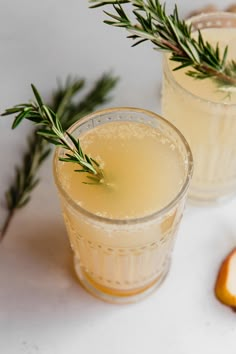 two glasses filled with lemonade and rosemary garnish