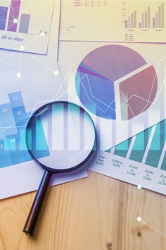 a magnifying glass sitting on top of a table next to papers and graphs