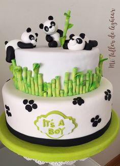 a three tiered cake with panda bears on the top and bamboo in the middle