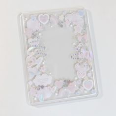 a square shaped mirror with hearts and stars on it's side, surrounded by other heart shapes