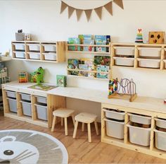 a child's playroom with wooden shelves and toy bins