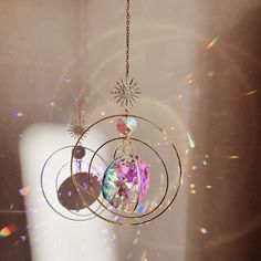 a wind chime hanging from a chain in the sun with some light shining on it