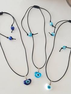 Evil eye chocker necklace is adjustable. There are two round evil eye beads and a heart shaped evil eye bead. The Evil eye pendant and the two round evil eye beads are made of glass. Cord color(flos rope) is black. Evil eye pendant color options are white, light blue and dark blue. Closure is a macrame sliding knot. Lenght of the nazar necklace is between 14 in- 24in. Width of the heart shaped evil eye pendant is 0.39 in(1 cm) For more evil eye necklaces, click the link below; https://www.etsy.c Adjustable Evil Eye Choker Necklace, Adjustable Evil Eye Spiritual Necklace, Adjustable Spiritual Evil Eye Necklace, Nazar Necklace, Evil Eye Choker, Jewelry Evil Eye, Necklace Evil Eye, Turkish Eye, Chocker Necklace