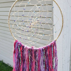 a colorful dream catcher hanging on the side of a house