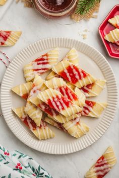 several pieces of ravioli on a plate next to a jar of jelly and christmas decorations