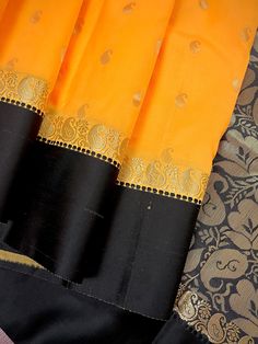 Gorgeous Statement designer Saree by Kaash Collection.  Yellow Saree with small Buttis all over the body of the Saree. Plain Black Color Borders and Zari Weaved Pallu in ambi Style.  Item : Saree Color : Yellow and Black Base Fabric : Soft Banarasi Silk  Blouse piece : Comes with Blouse piece Blouse material : Soft Banarasi Silk  Work : Handloom  Fall & Edging(Yes/No) : Yes Disclaimer -: - Color variation is possible due to various reasons like phone or desktop setting, resolution etc. Please don't hold us responsible. Our aim is to put the exact color of the Saree. - If the Saree is Pure Silk, we will put it very clearly in our listing that it is Pure Silk. If we do not mention its Pure Silk please do not assume it is Pure Silk. When in doubt please feel free to check with us. - Thread co Orange Saree With Border For Wedding, Orange Traditional Wear With Printed Border For Festive Occasions, Festive Orange Traditional Wear With Printed Border, Orange Wedding Saree With Border, Festive Chanderi Churidar With Printed Border, Gold Traditional Wear With Printed Border, Traditional Gold Wear With Printed Border, Yellow Traditional Wear With Printed Border, Traditional Yellow Wear With Printed Border