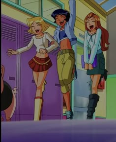 two girls are standing in front of lockers and one girl is holding her hand up