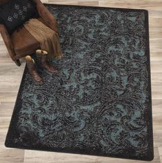 a person sitting on a chair in front of a rug with an ornate pattern and brown boots