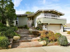 a large house with landscaping in front of it and steps leading up to the door