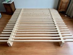 a wooden bed frame sitting on top of a hard wood floor