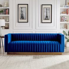 a living room with white walls and blue velvet couch