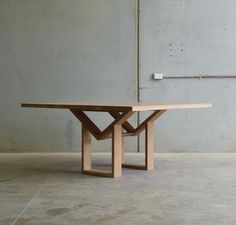 a wooden table sitting on top of a cement floor