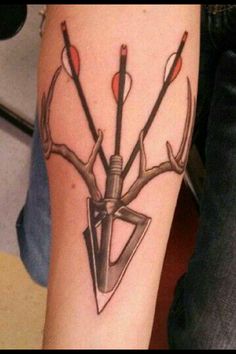 a tattoo on the arm of a person with an arrow and two arrows in it