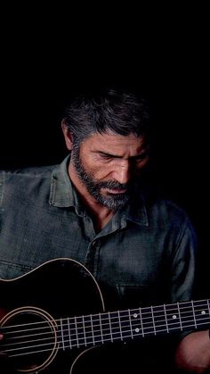 a man playing an acoustic guitar in the dark