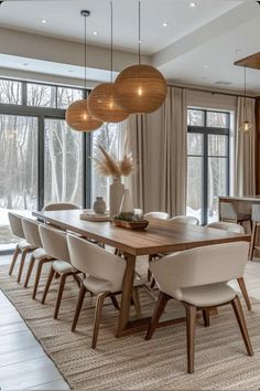 a dining room table surrounded by chairs and lights