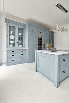 a large kitchen with blue cabinets and white counter tops in an open floor plan area