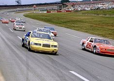 a group of cars driving down a race track