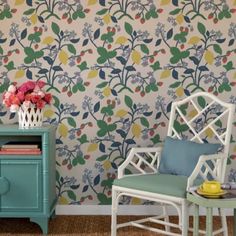 two chairs and a table in front of a wallpapered room with flowers on it