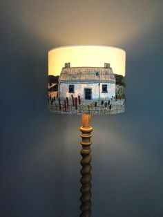 a lamp that has a house on it and is lit up with the light turned on