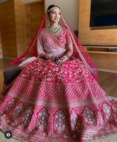 a woman in a red and pink bridal gown